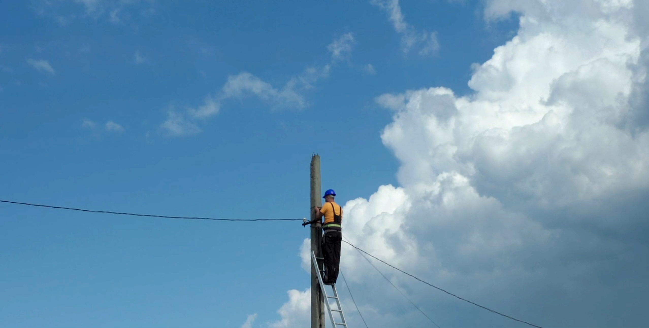 A still from Please Hold The Line. A man fixing a telephone wire.