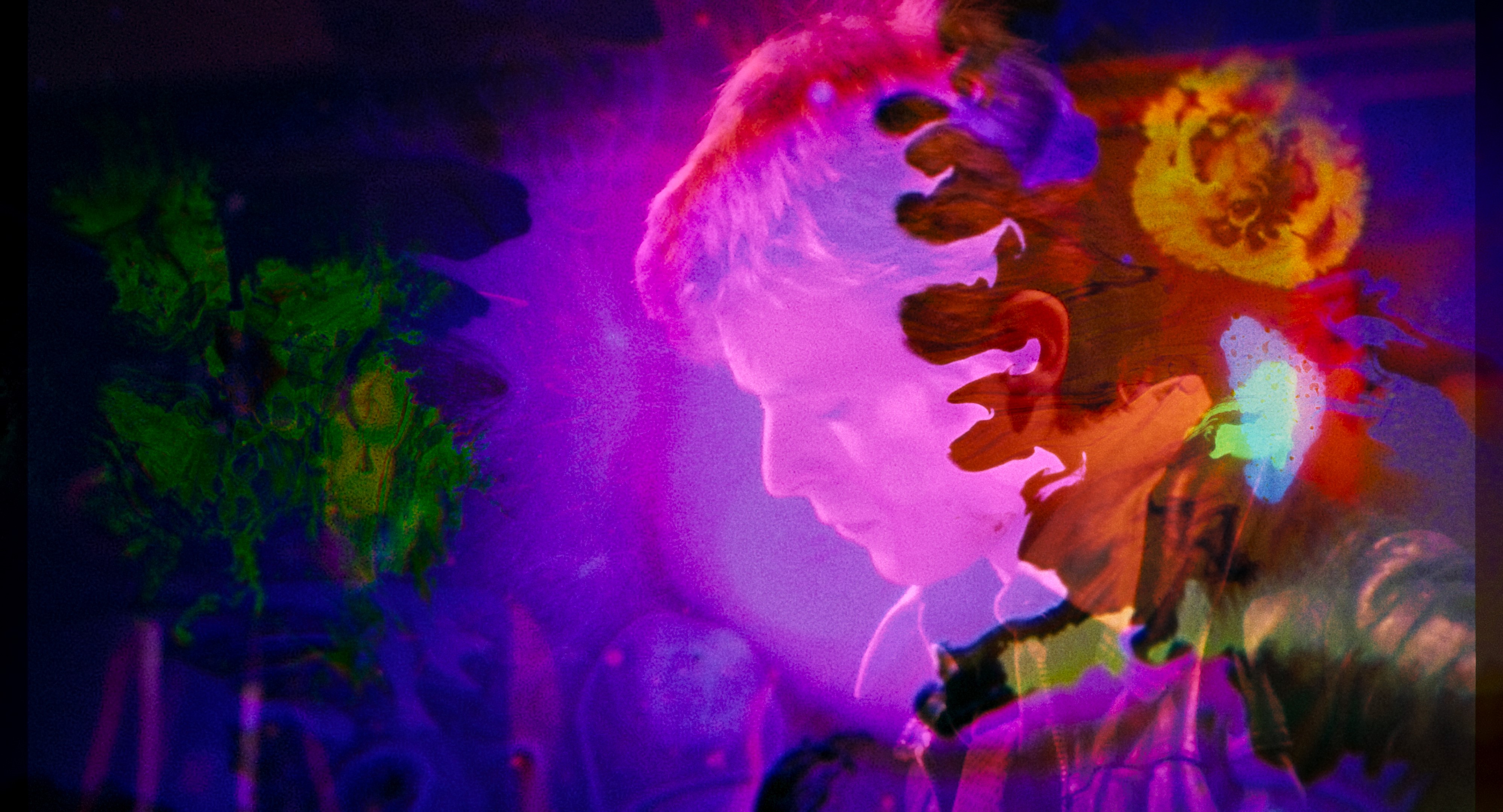Side profile image of David Bowie, edited to include multiple colour light leaks across the image.