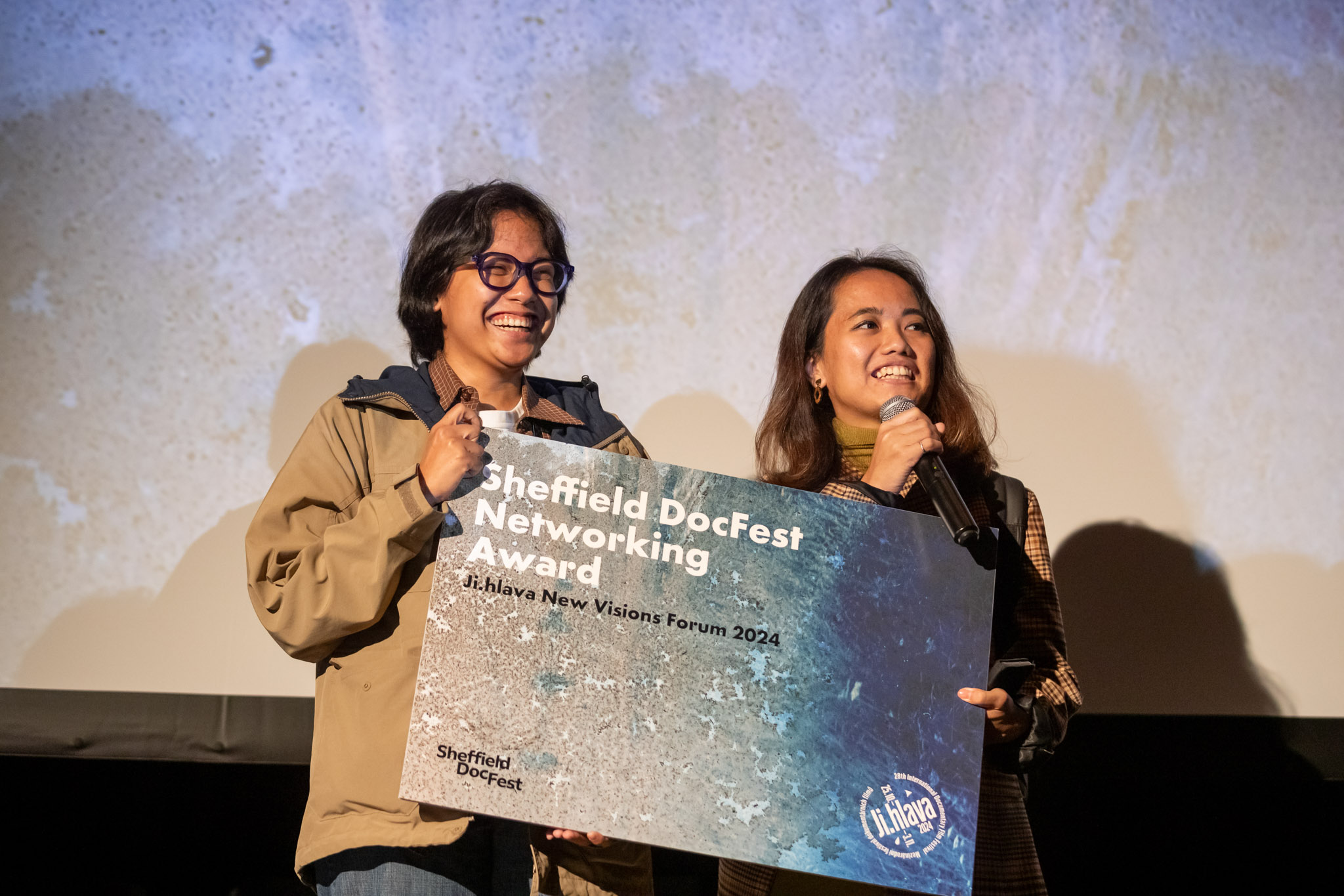 Two people smiling holding a certificate