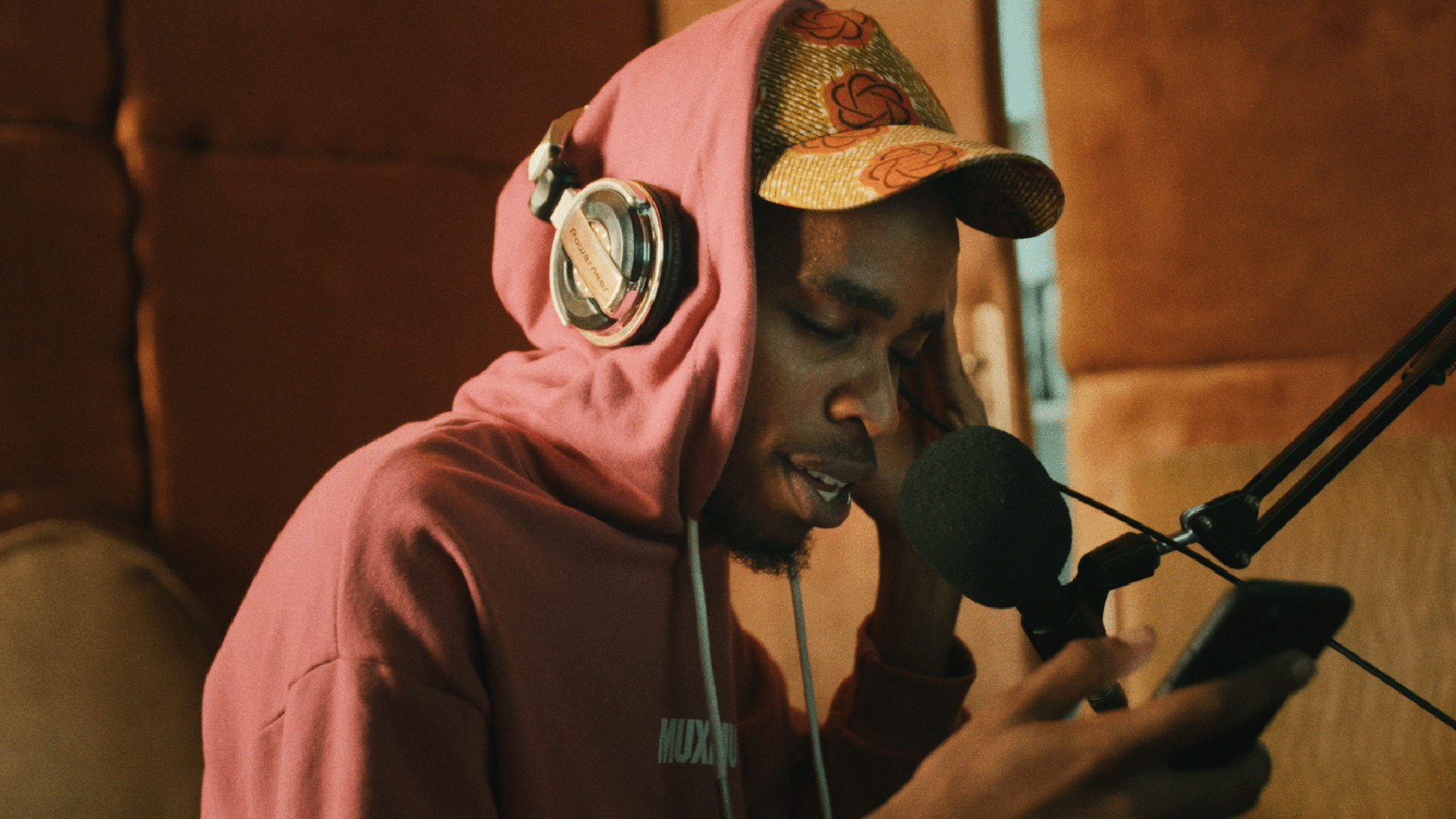 A man wears headphones and recites poetry