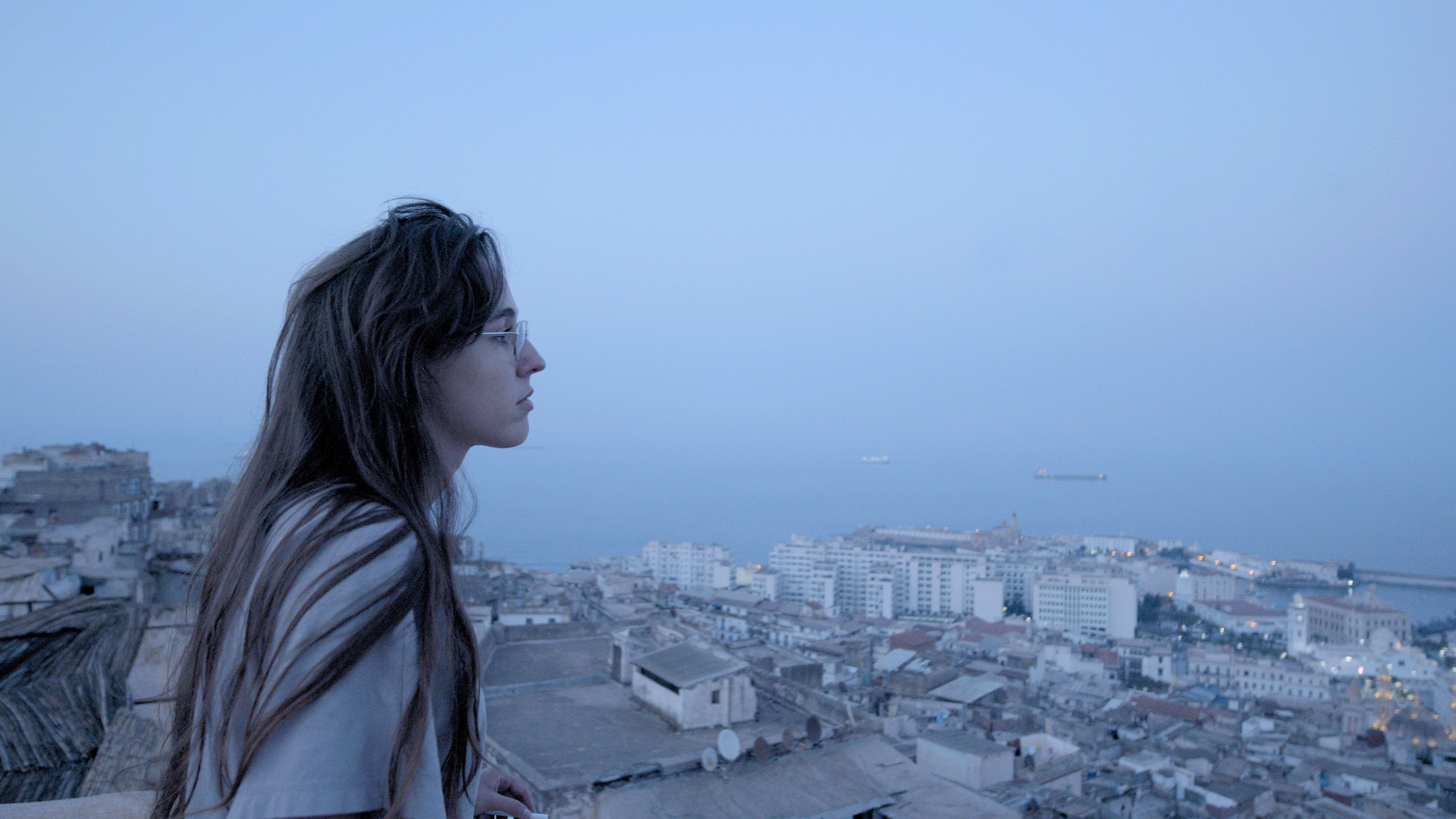 A girl staring at the city. A still from the film Magma. 