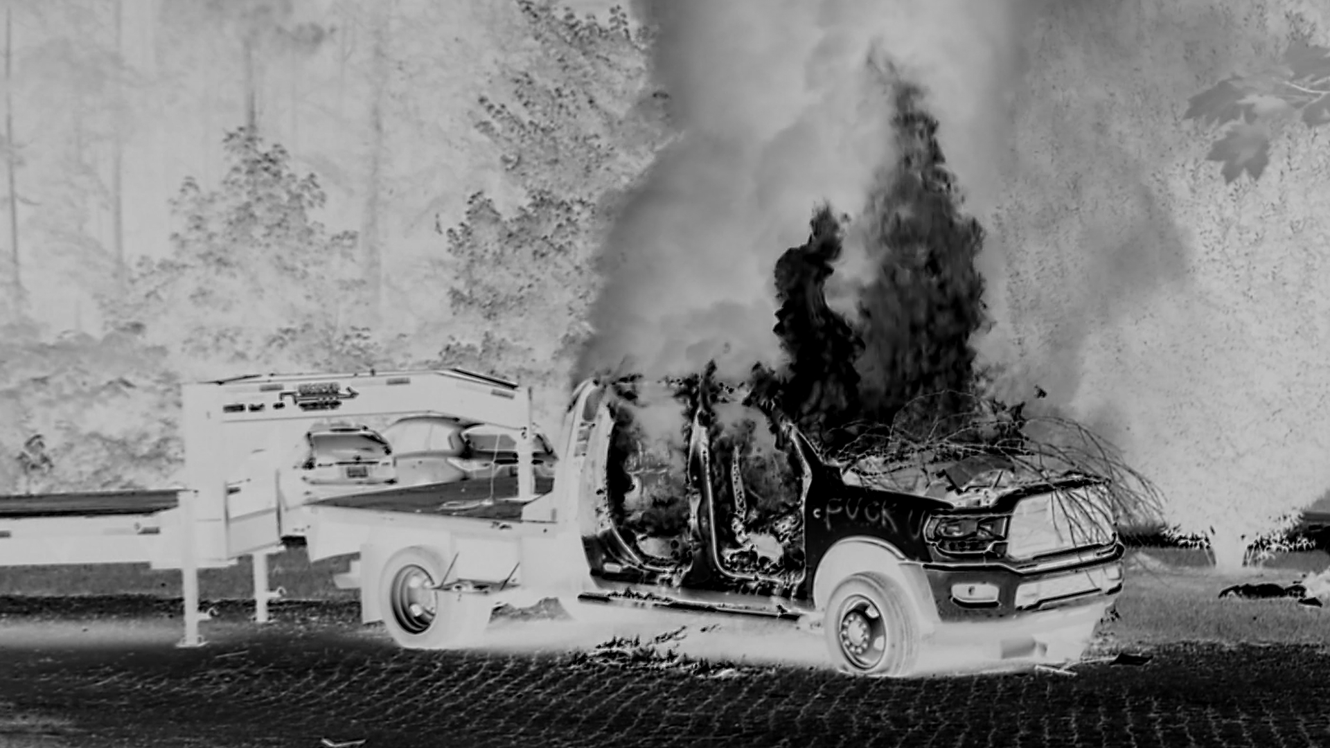 A car burns in black and white picture.