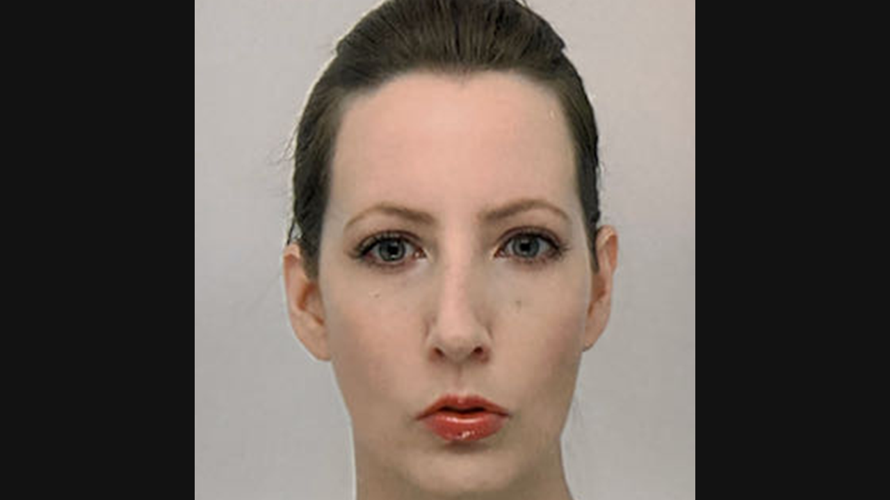 Image of a white woman with dark brown hair, tied back. She has a serious face, and is pictured against a white background