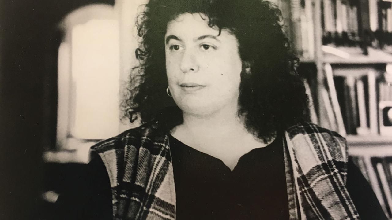 Andrea Dworkin sat in front of a bookcase