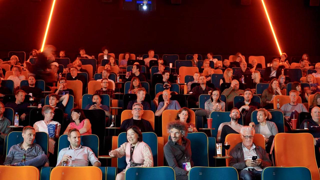 An audience sits in an auditorium, ready to watch a film.