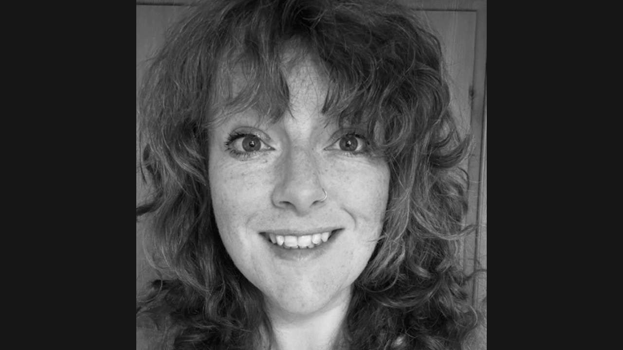 Maria Stoneman headshot. A black and white image of a white woman with brownish curly hair with a fringe.