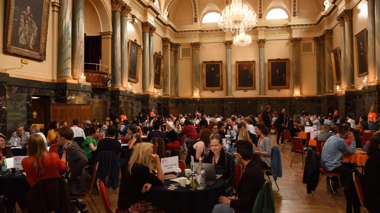 room of people taking meetings at round tables