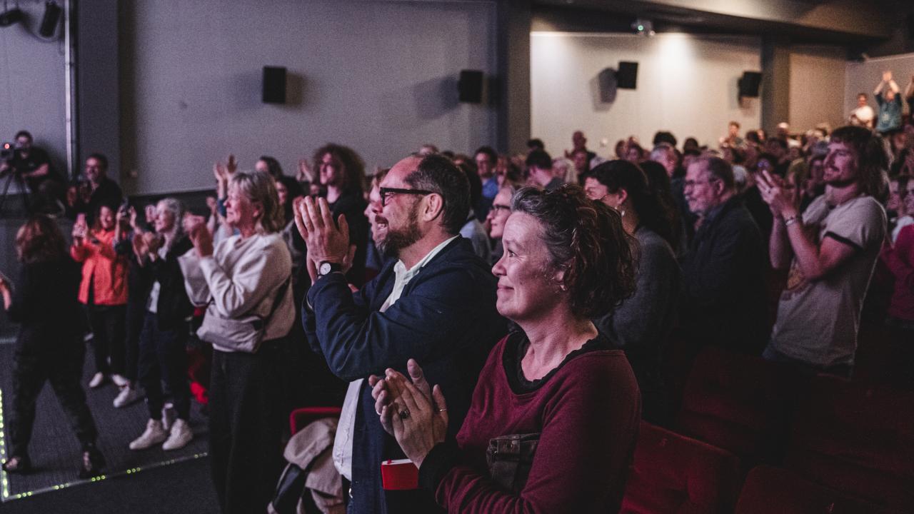 Crowd of people in a cinema giving a standing ovation