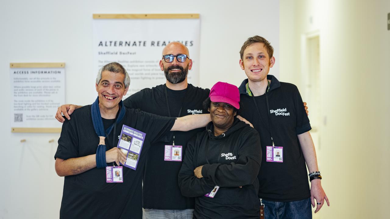 A group of volunteers stood in their DocCrew t-shirts smiling widely at the camera