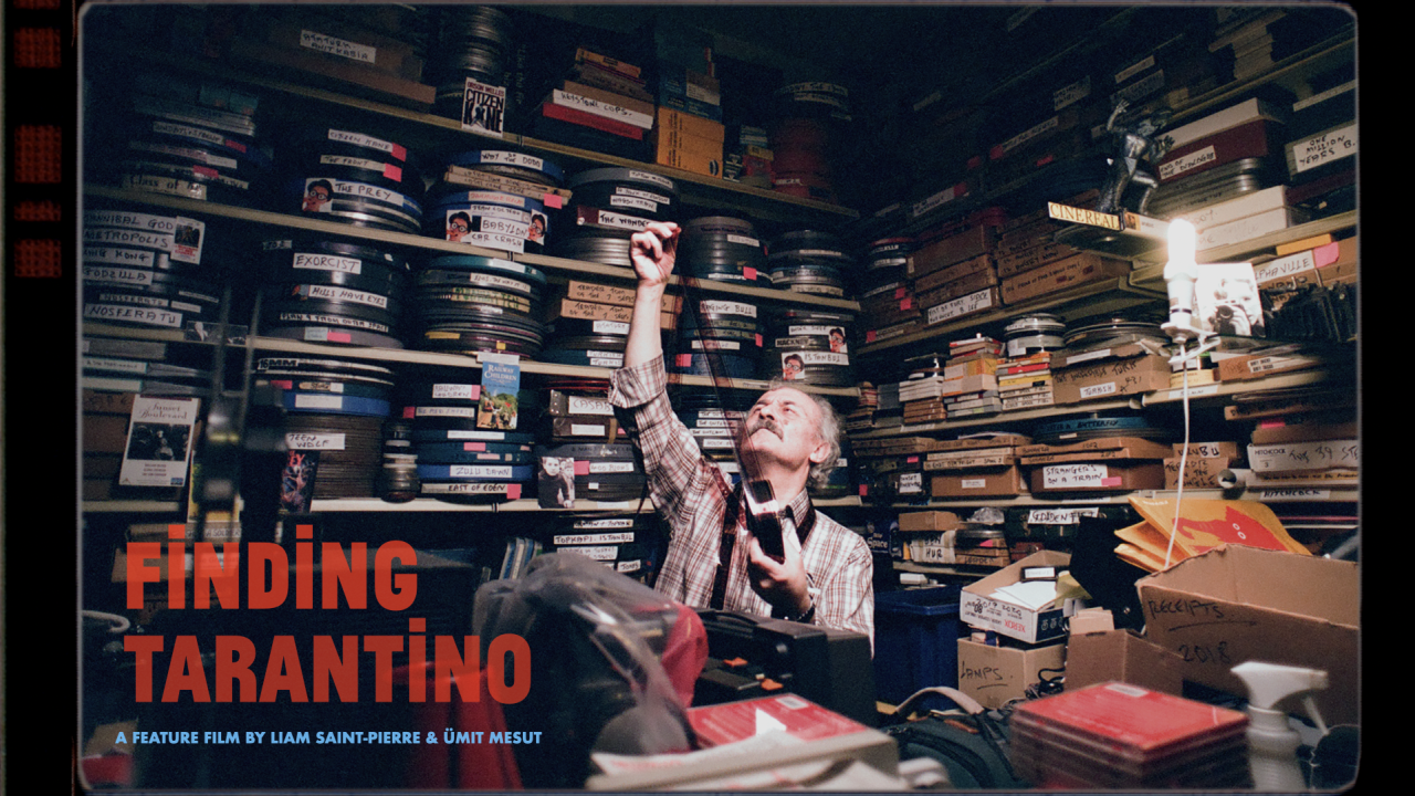 A man with grey hair examines a strip of film in a cluttered room filled floor-to-ceiling with labeled film reels, boxes, and VHS tapes.