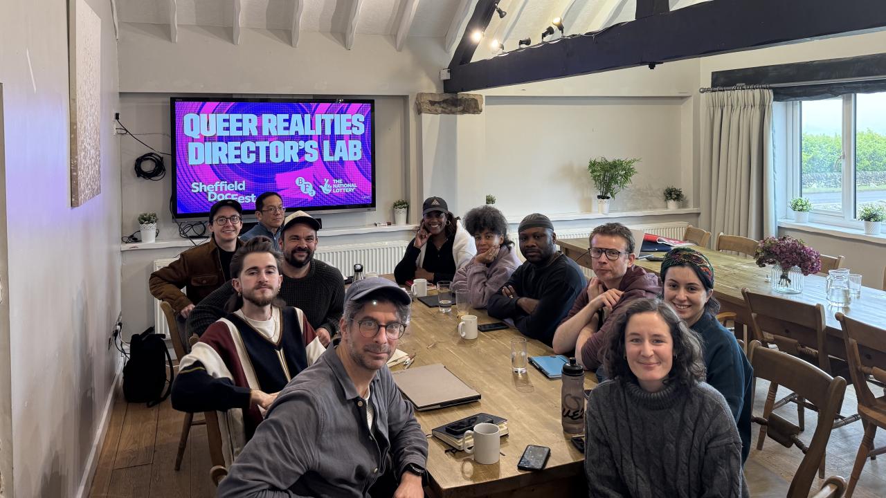 The Queer Lab cohort sit round a table.