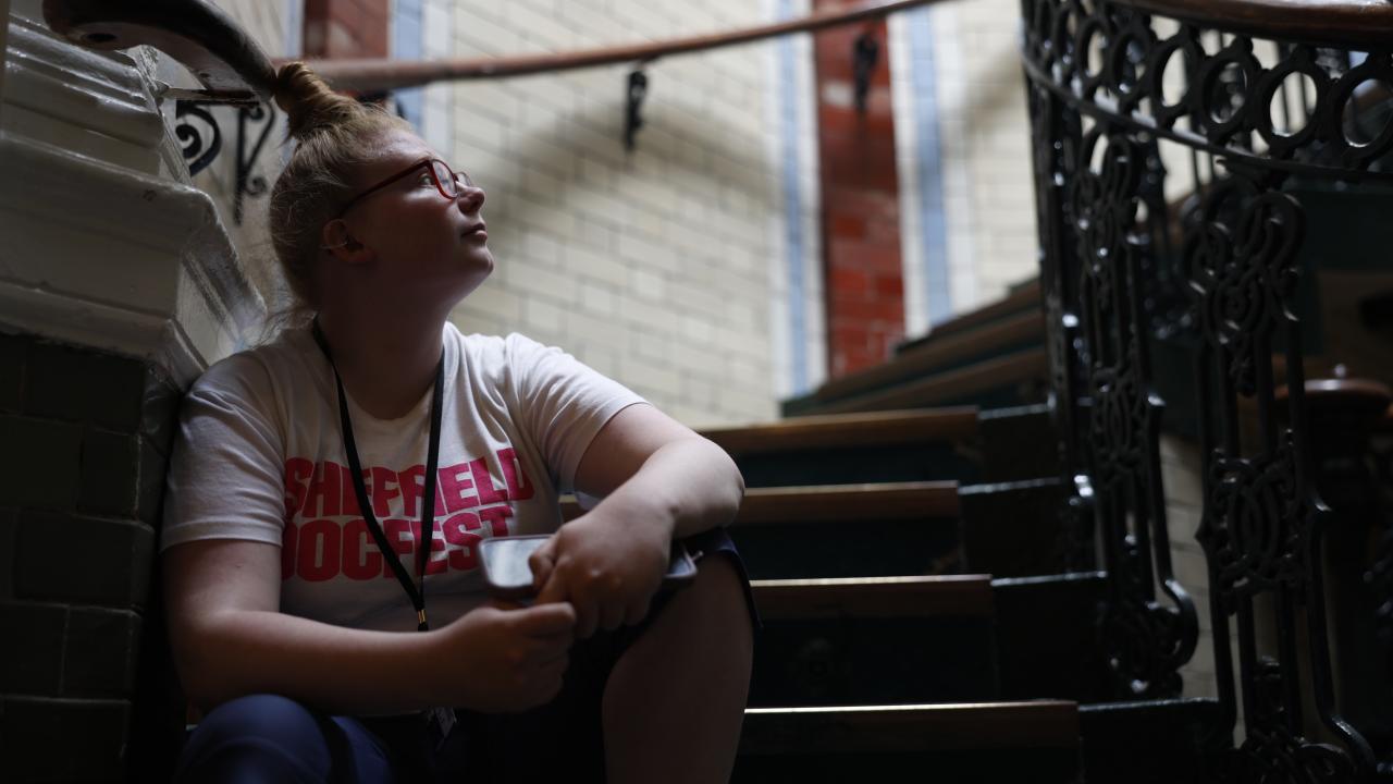 A Sheffield DocFest volunteer looks across a staircase.