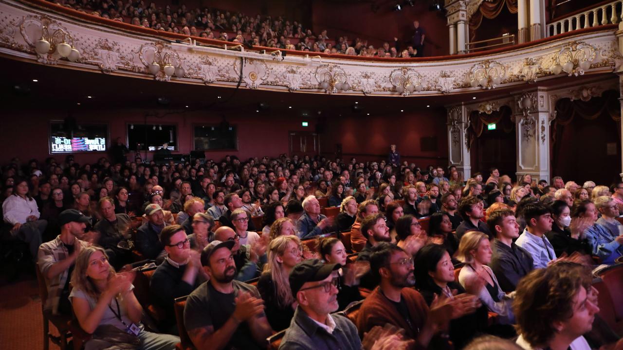 A busy audience clapping in applause.