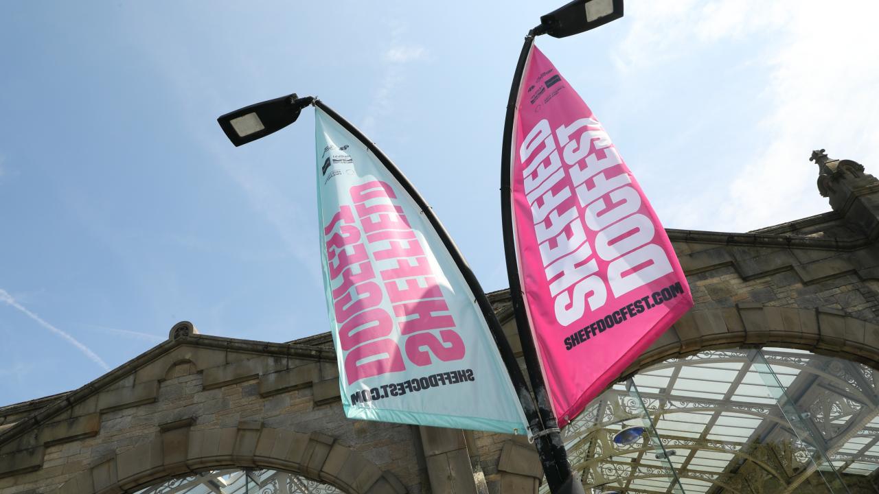 A DocFest flag in front of Sheffield train station.