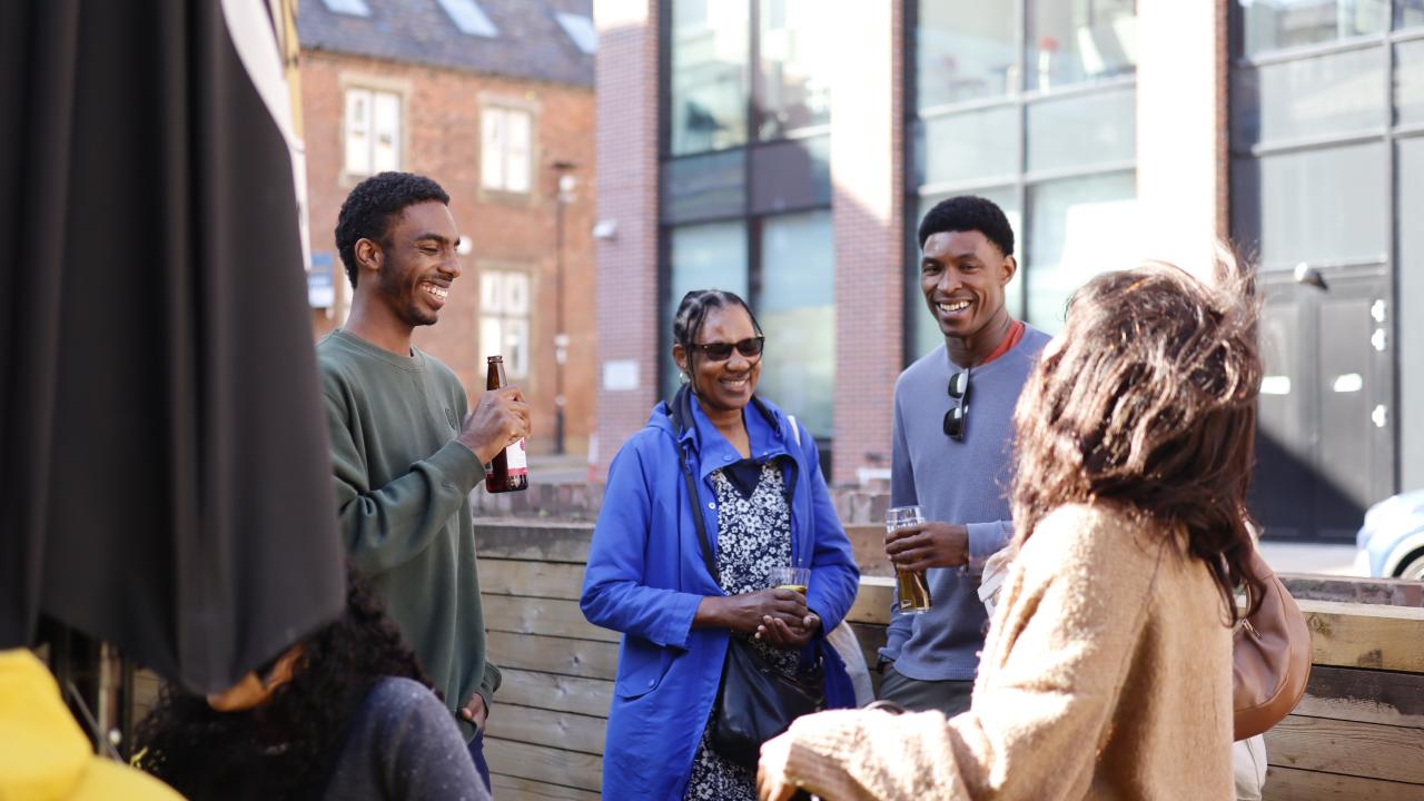 A group of people stand with drinks in their hands at an event.