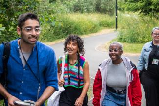 A group of people attending Sheffield DocFest walk through a park.